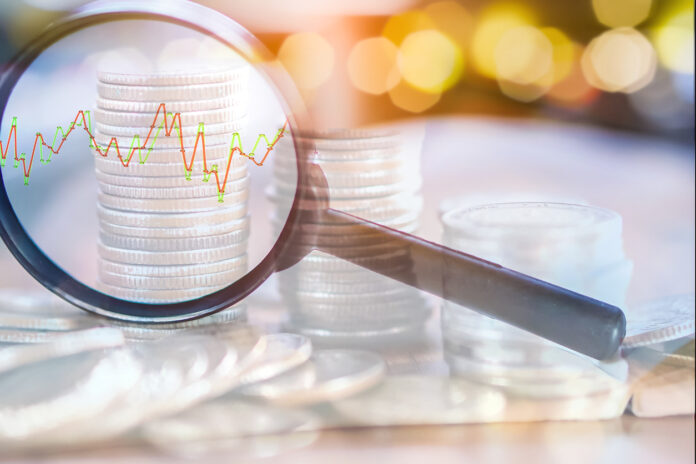 double exposure business concept magnifying glass focus on coins